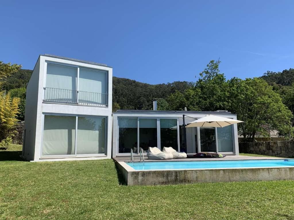 卡米尼亞的住宿－Lovely Caminha Villa - 3 Bedrooms - Villa Lilac - Private Pool and Beautiful Views - Viana do Castelo，一座带游泳池和遮阳伞的房子