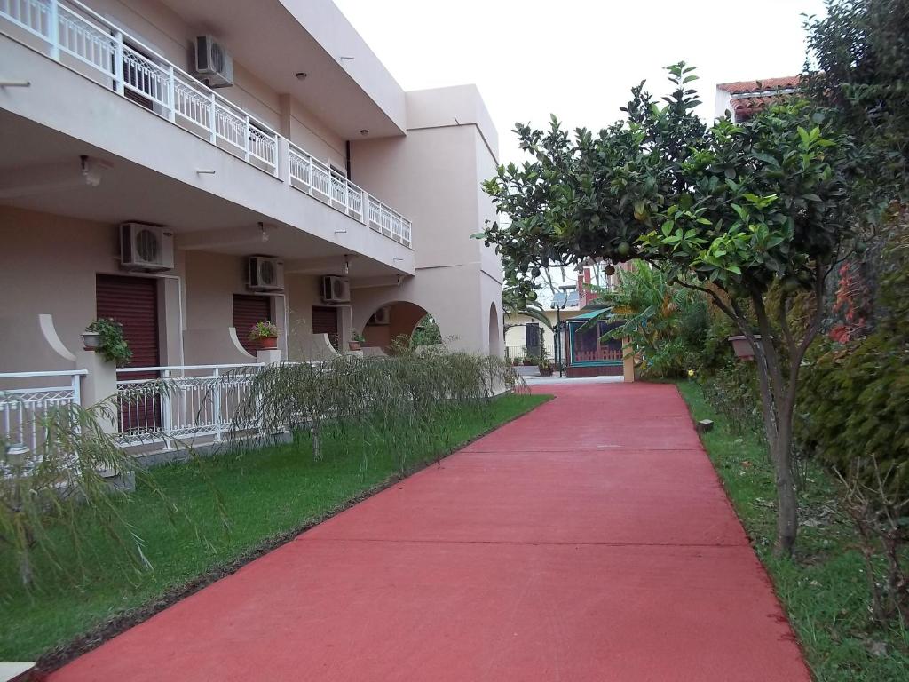 a red sidewalk in front of a building at Toula's Apartments in Sidari