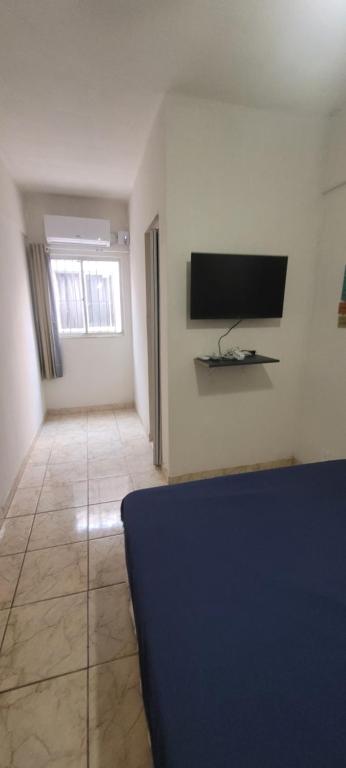 a living room with a flat screen tv on a wall at Maravilhosa Kitnet 10 min da praia in Vila Velha