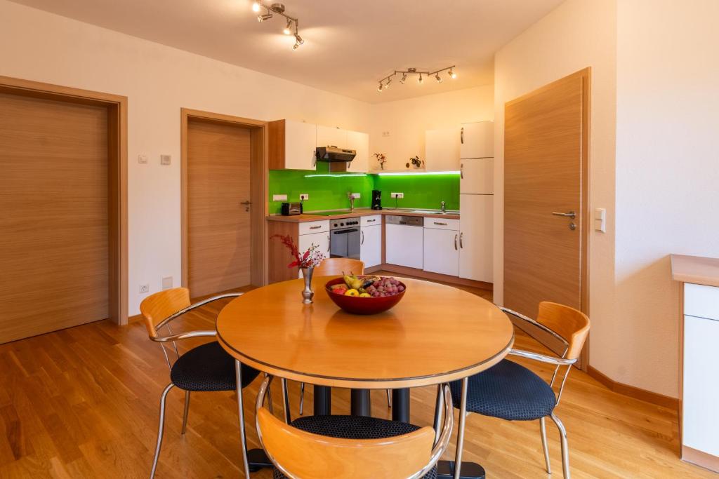 een keuken en eetkamer met een houten tafel en stoelen bij Ferienwohnung s'Kammerl in Wolfegg