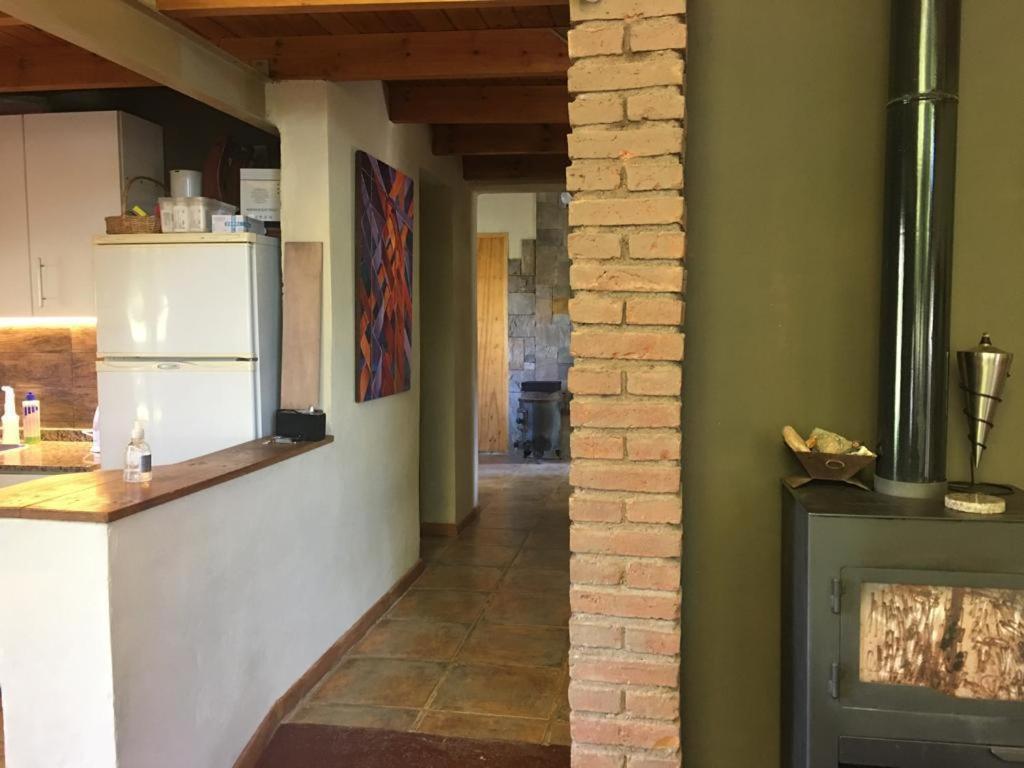 a kitchen with a white refrigerator and a fireplace at Casa de Montaña Uspallata, Mendoza in Estación Uspallata