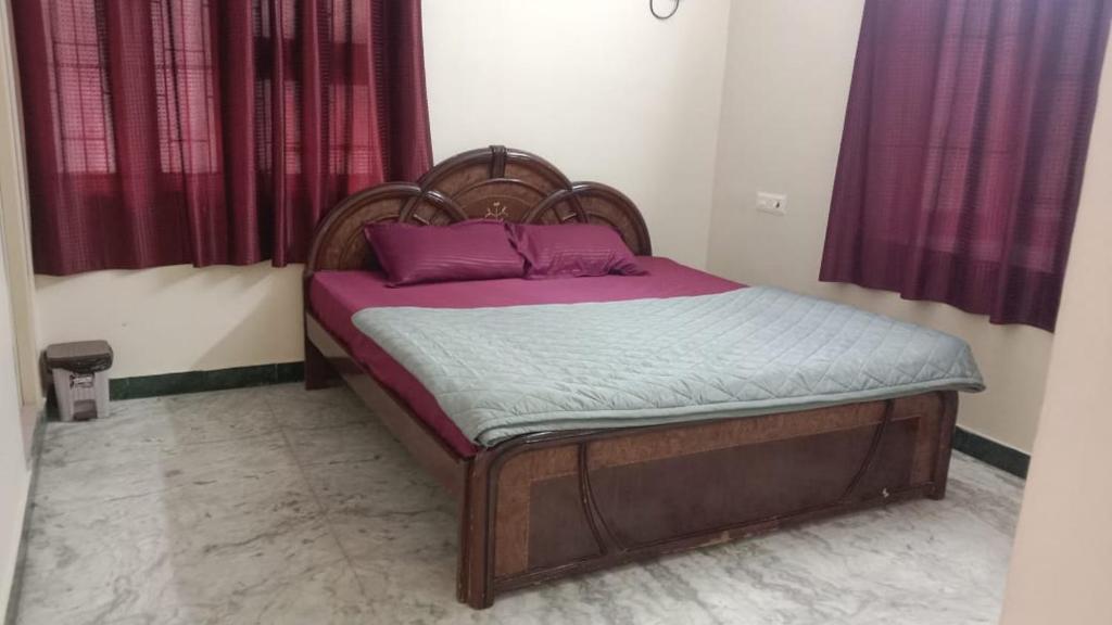 een klein bed met paarse kussens in een slaapkamer bij MSD villa in Pondicherry