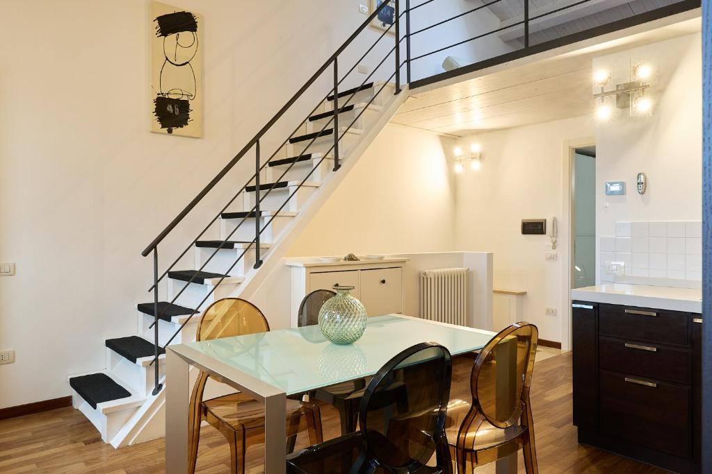 a dining room with a table and chairs and a staircase at Loft del Faro in Fano