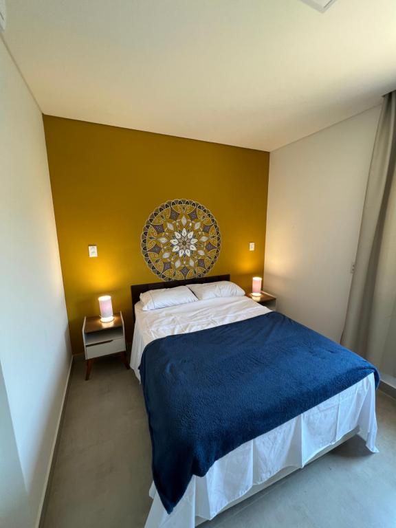 um quarto com uma cama grande e uma parede amarela em Casa Beija-Flor em Paraty