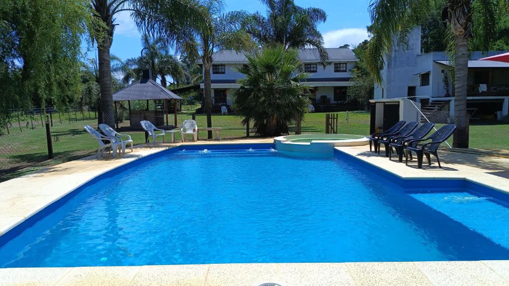 una piscina con sillas, una mesa y un edificio en Cabañas del Paraiso en Colón