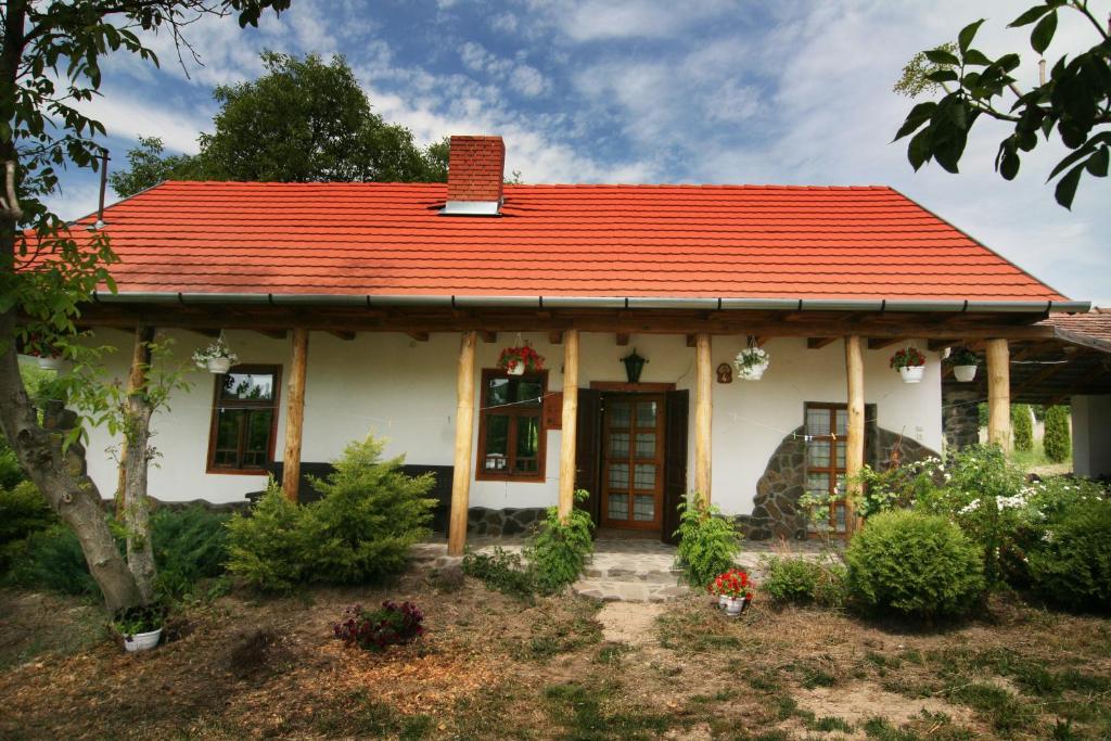 ein kleines weißes Haus mit orangefarbenem Dach in der Unterkunft Bableves Vendégház in Felsőtold