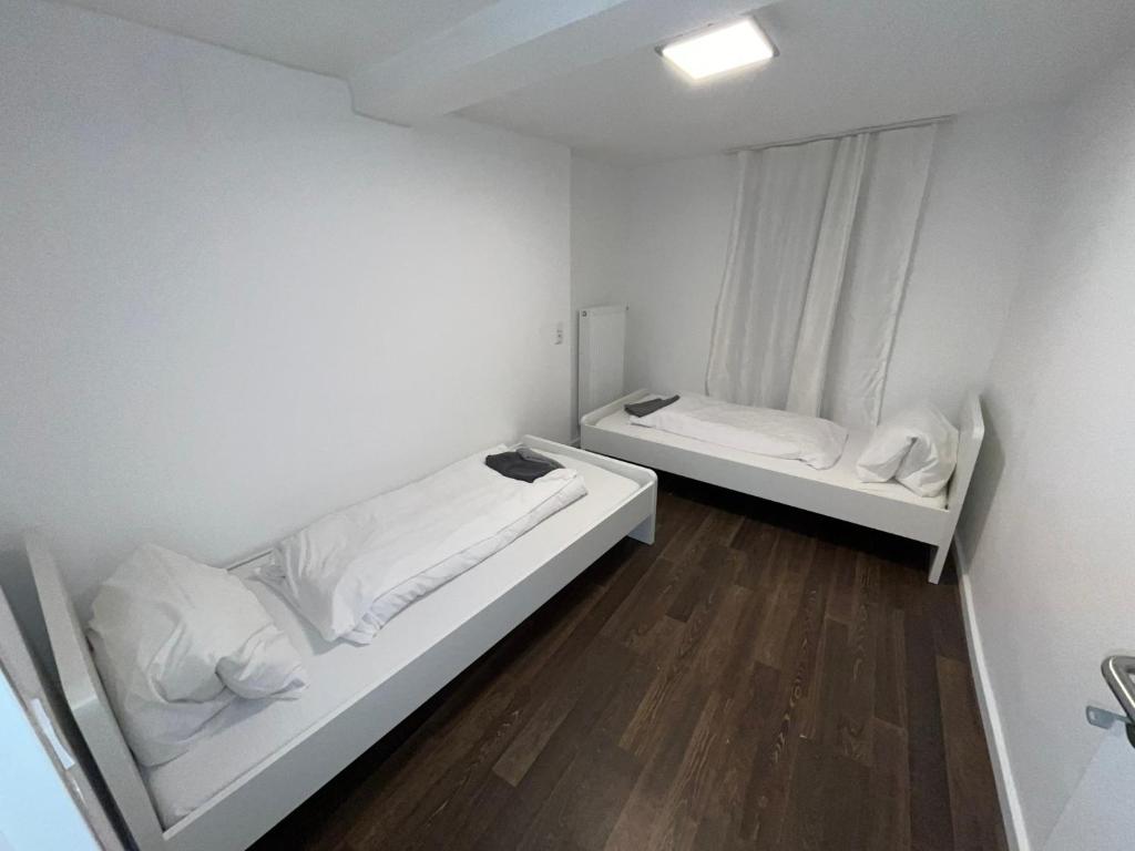 a white room with two beds and a window at Wohnungen bei Post in Hünfelden