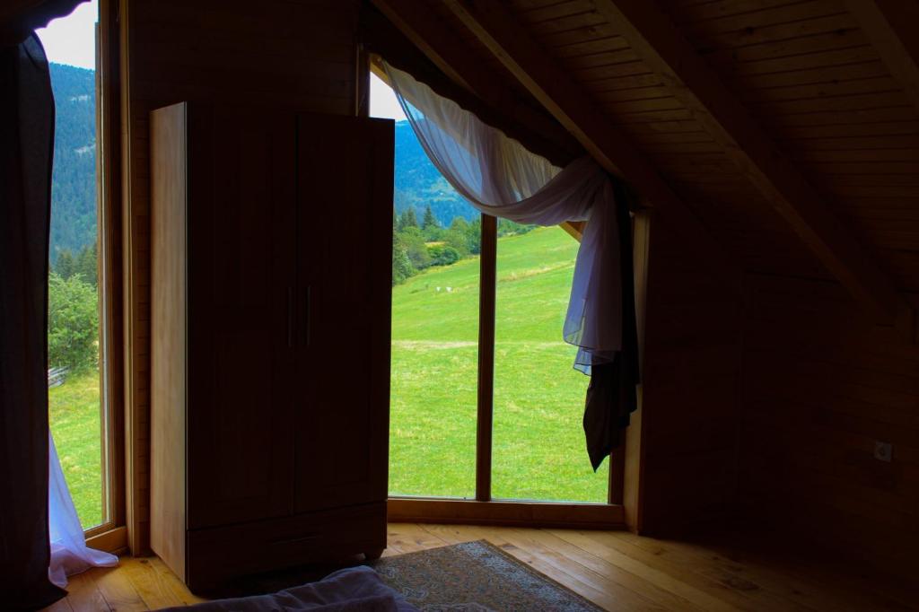 a room with a window with a view of a green field at Oaza Mira Hotel & Resort-فندق ومنتجع واحة الهدوء in Vlasic