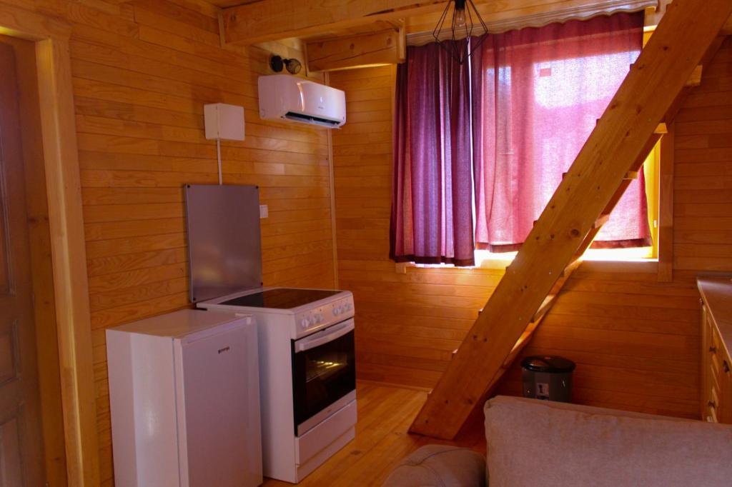 a kitchen with a stove and a refrigerator in a cabin at Oaza Mira Hotel & Resort-فندق ومنتجع واحة الهدوء in Vlasic
