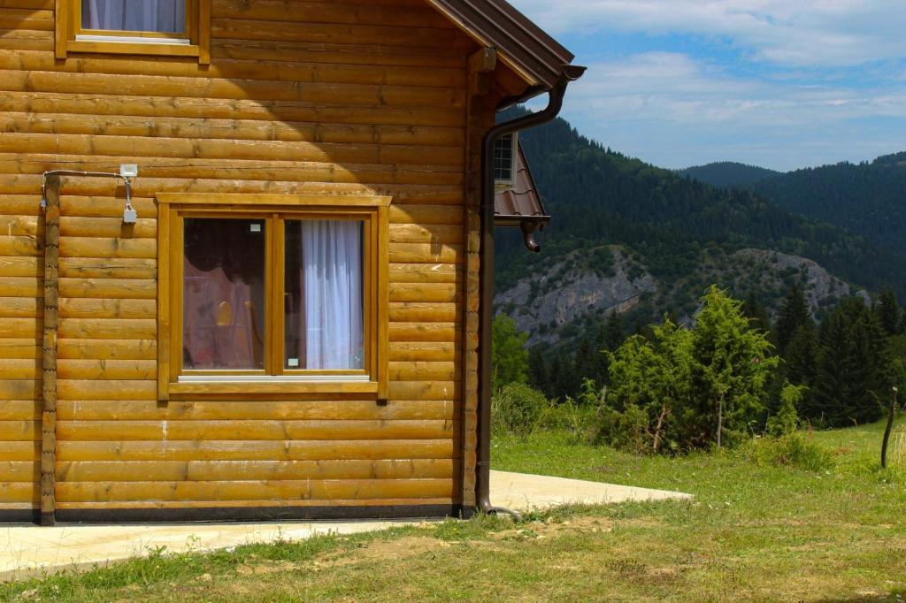 a log cabin with a window on the side of it at Oaza Mira Hotel & Resort-فندق ومنتجع واحة الهدوء in Vlasic