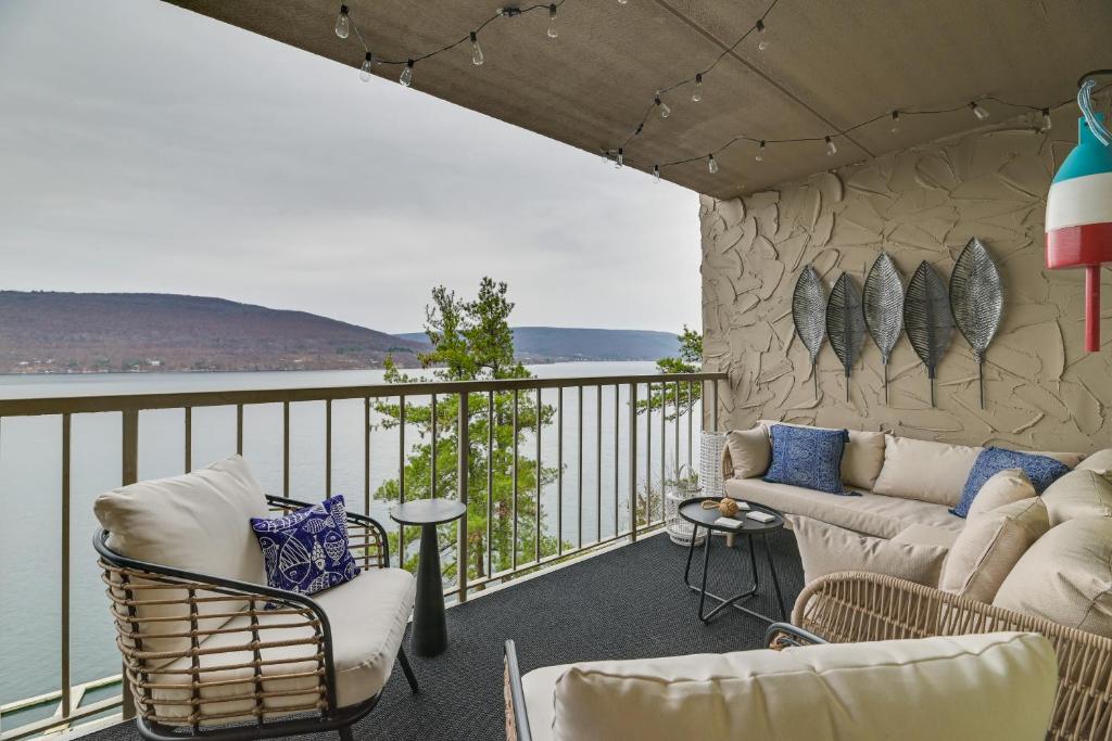 een woonkamer met een bank en stoelen op een balkon bij Lakefront Canandaigua Condo with Stunning Views in Rushville