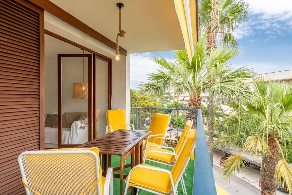 een balkon met een tafel en stoelen en palmbomen bij Apartamento Turístico Eme in Cambrils