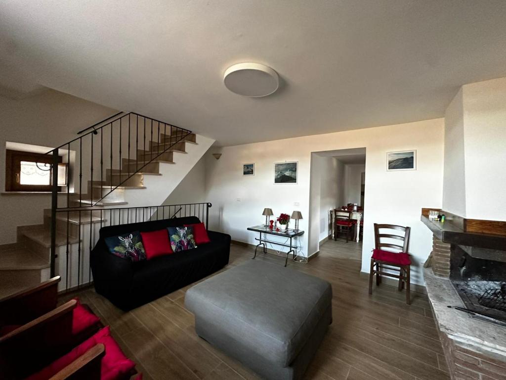 salon z czarną kanapą i schodami w obiekcie Red Cottage-Campo Felice w mieście Collimento