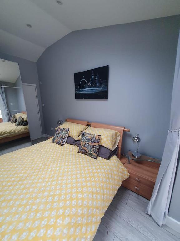 Lovely double room with en-suite bathroom في The Hyde: غرفة نوم بسرير ذو أغطية ومخدات صفراء