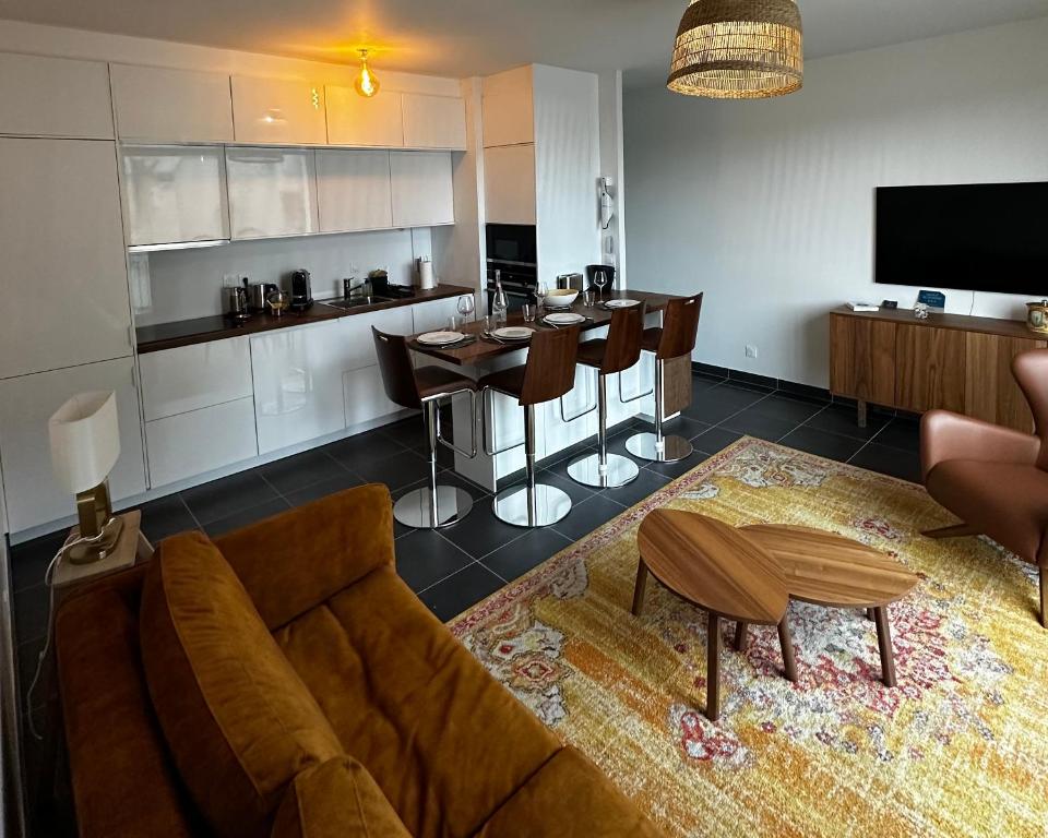 un salon avec un canapé et une table et une cuisine dans l'établissement Le National panoramique, à Tours