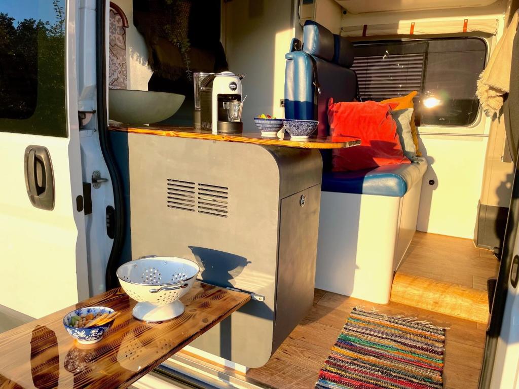 Ein Wohnwagen mit einer Theke und einem Tisch darin in der Unterkunft Camper Mykonos in Backnang