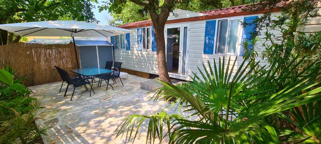 烏馬格的住宿－Kamp Slanik Mobile Homes，庭院配有桌椅和遮阳伞。