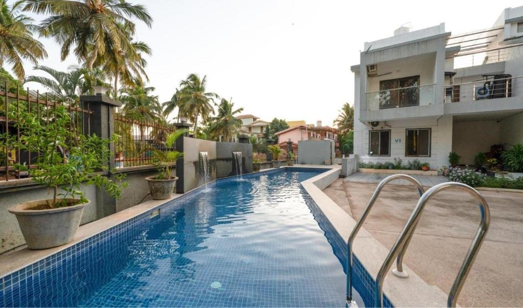 a swimming pool in front of a building at Luxury 2BHK Apartment Near Candolim in Nerul