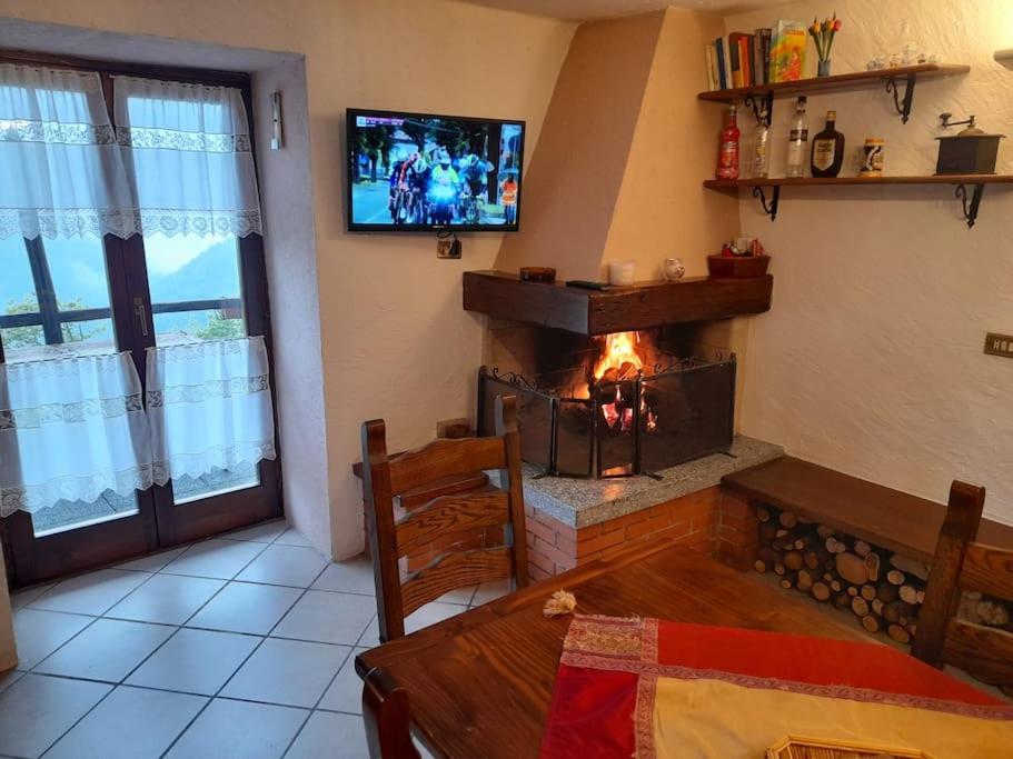 a living room with a fireplace and a television at Chalet Alpe Quaggiui in Calasca Castiglione