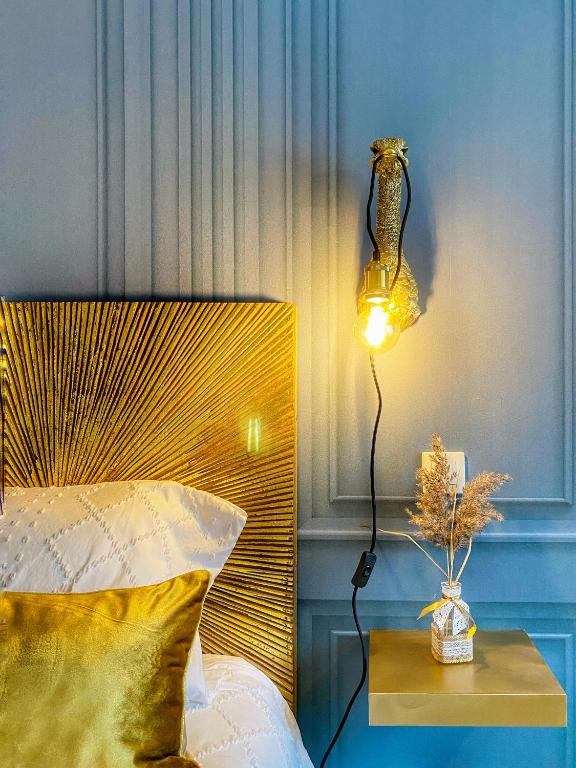 une lampe sur une table à côté d'un lit dans l'établissement DELUX Le MARQUIS, à Saverne