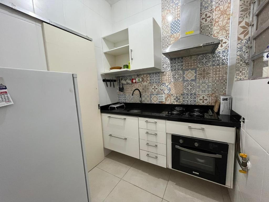 uma pequena cozinha com um fogão e um frigorífico em Apartamento em Botafogo no Rio de Janeiro