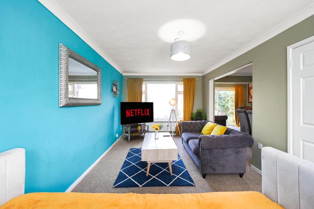 - un salon avec des murs bleus et un canapé dans l'établissement 4 Bed House with Parking and Garden - Sleeps 8, à Kent