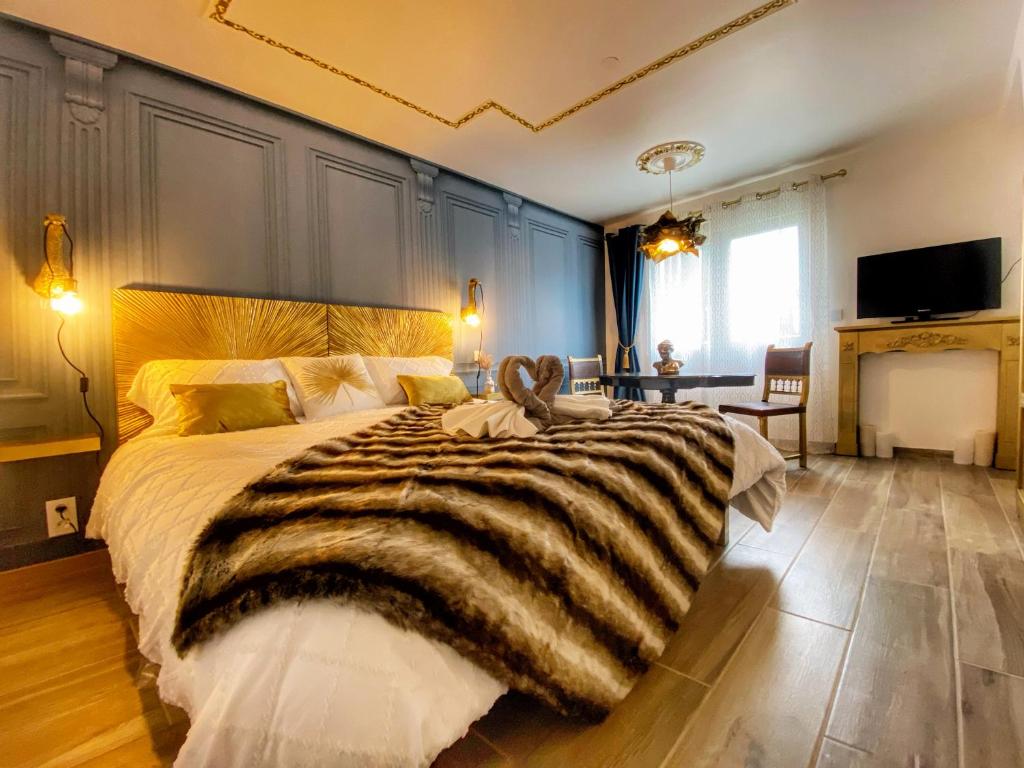 ein großes Schlafzimmer mit einem großen Bett mit einer Decke in der Unterkunft DELUX Le MARQUIS in Saverne