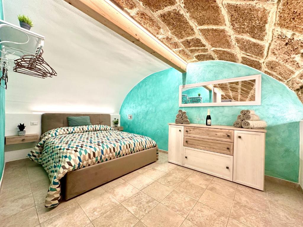 a bedroom with a bed and a stone wall at POMA DE CASA - Carrer de Pa i Algua in Alghero