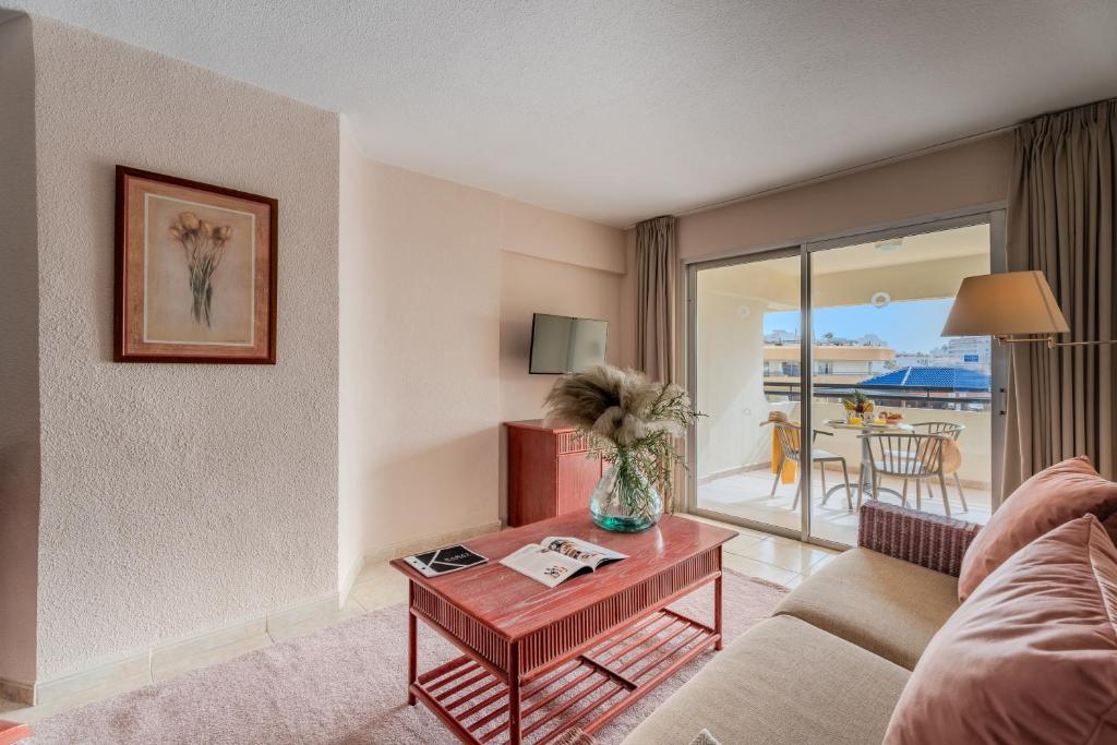 een woonkamer met een bank en een tafel bij OBSIDIAN Apartamento Santa María in Adeje