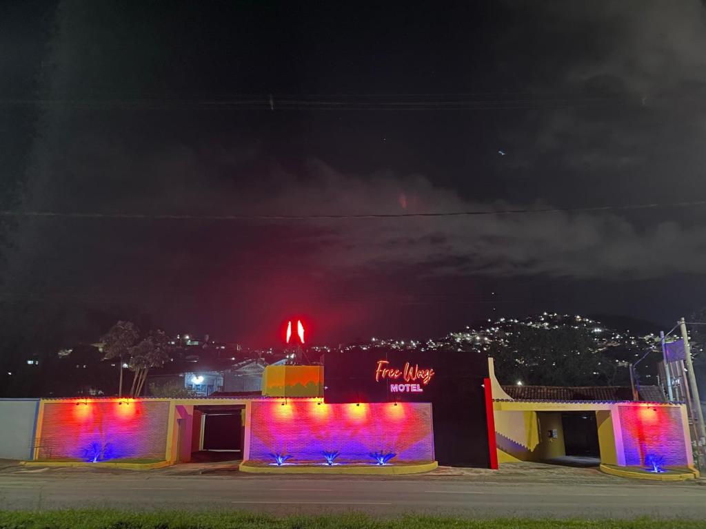 um edifício com luzes coloridas à noite em Free Way Motel em Poços de Caldas