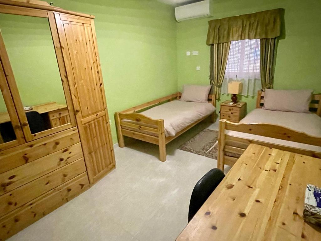 - une chambre avec 2 lits, un miroir et une table dans l'établissement Regent Court - 3 bedroom apartment within walking distance from Bugibba seafront, à San Pawl il-Baħar