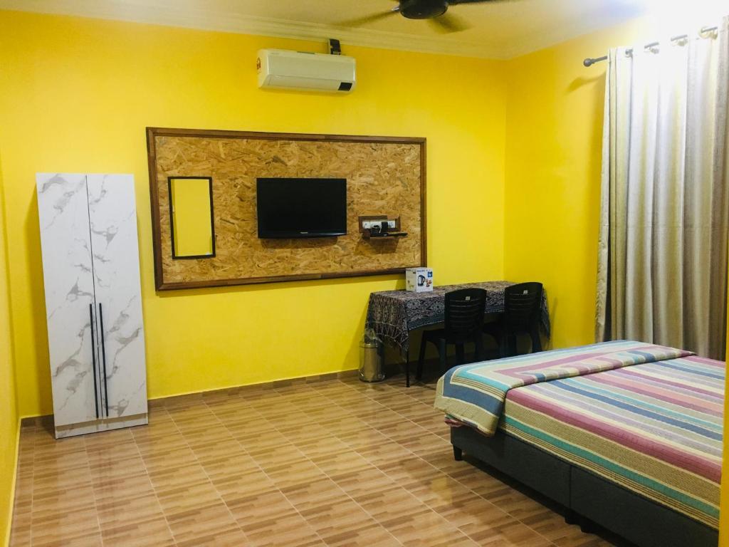 - une chambre avec un lit, une table et une télévision dans l'établissement The Pines Studio @ PCB (deluxe), à Kota Bharu