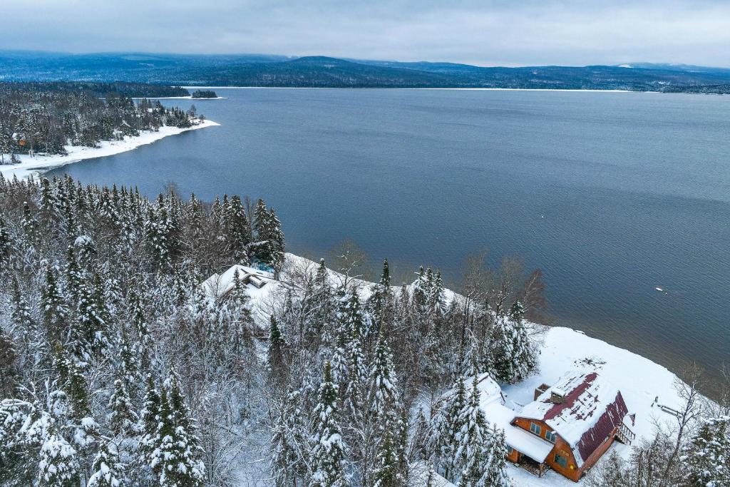 an aerial view of a lake with snow covered trees at Pittsburg Lake House with Magalloway Mountain Views! in Pittsburg