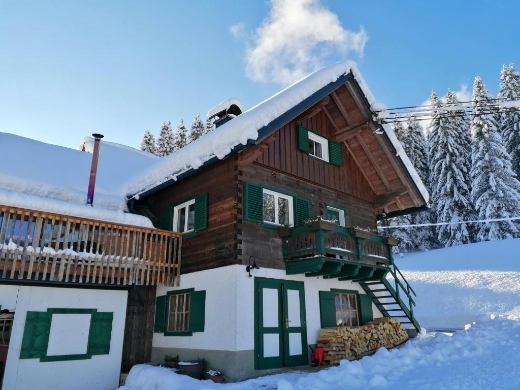 une cabane en rondins dans la neige dans l'établissement Ferienhaus Asterbach, à Gosau