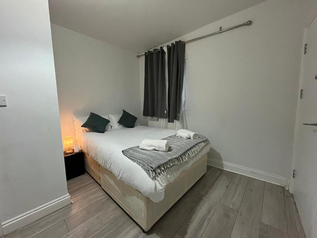 a bedroom with a bed with two towels on it at City Apartments near Seven Sisters in London