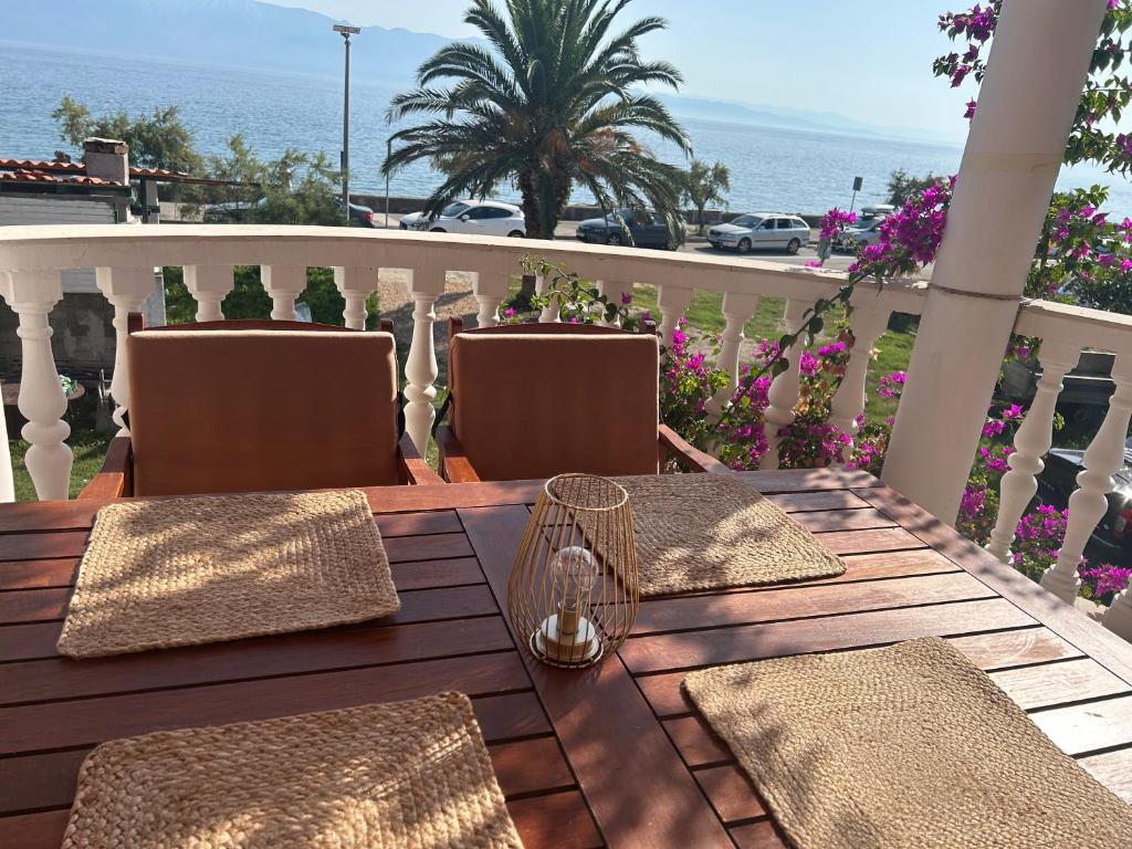 a wooden table with chairs on a balcony with the ocean at Apartmani Pavlović in Sućuraj