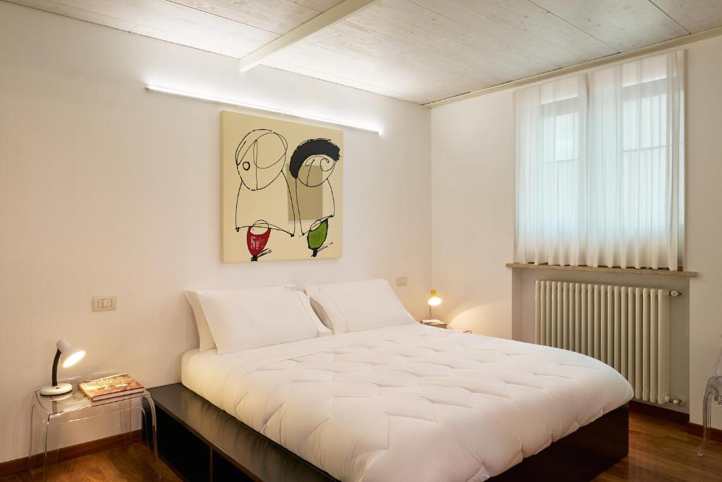 a bedroom with a large white bed and a window at Loft del Faro in Fano