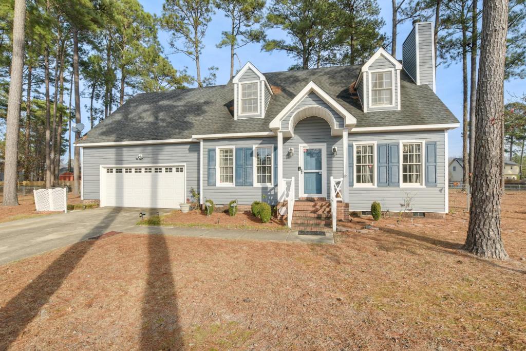 Lovely Fayetteville Home Deck and Fireplace! في فايتفيل: منزل أبيض مع شجرة في الممر