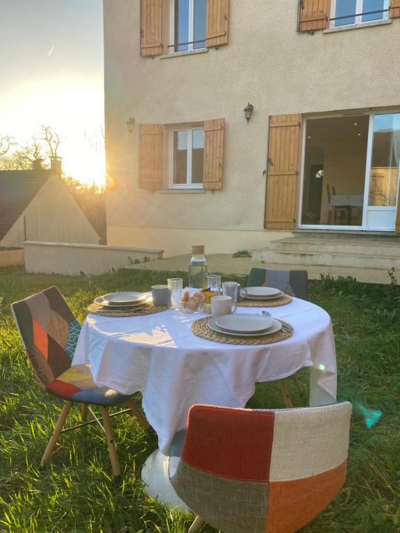une table avec des plaques de nourriture dans l'herbe dans l'établissement Maison Paisible à 15 min de Disneyland !, à Crégy-lès-Meaux