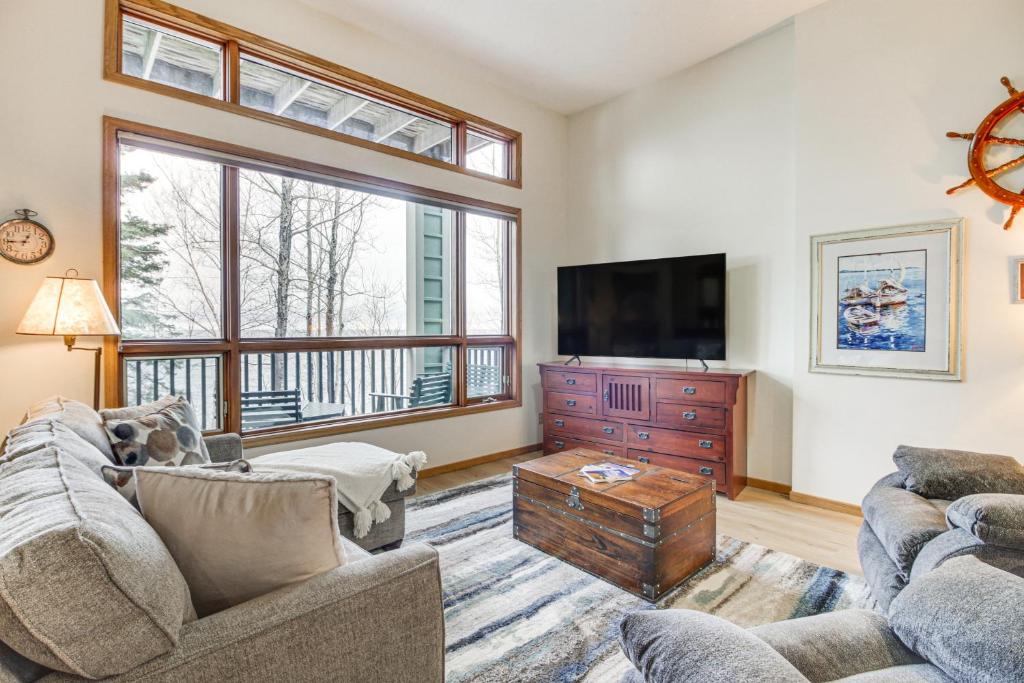 a living room with two couches and a flat screen tv at Lakefront Tofte Townhome with Deck and Views! in Tofte