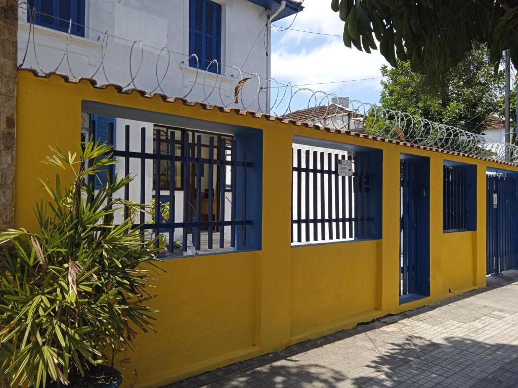 un edificio amarillo con puertas y puertas azules en HOSTEL DA VILA, en Santos