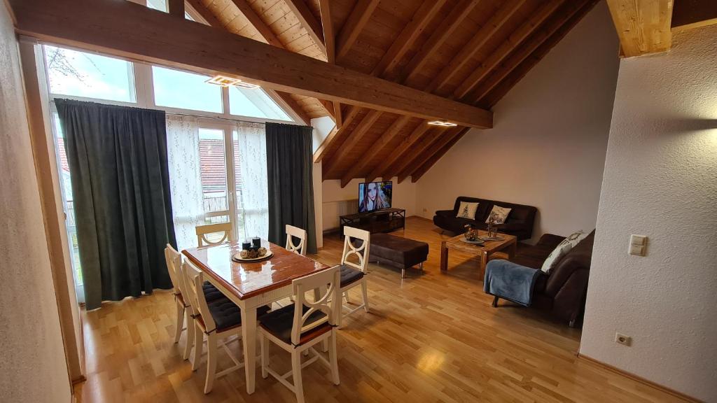 een woonkamer met een tafel en stoelen en een woonkamer met een bank bij Ferienwohnung CELI in Rottweil