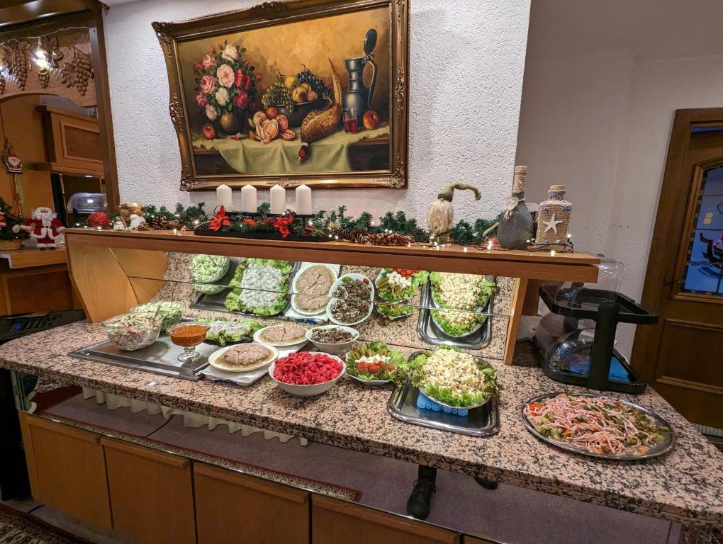 un buffet avec des assiettes de nourriture sur un comptoir dans l'établissement City Hotel - Doppelzimmer, à Rastatt