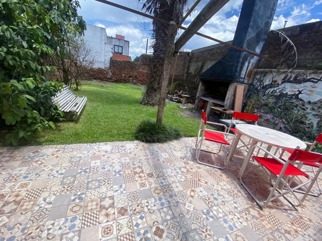 eine Terrasse mit einem Tisch, Stühlen und einem Grill in der Unterkunft Casa a una cuadra de costanera Gualeguaychu Hasta 8 personas in Gualeguaychú