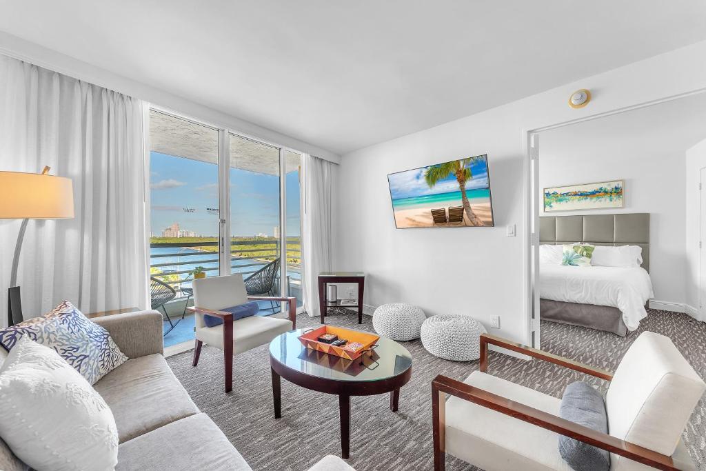 een woonkamer met een bank en een bed bij Eternal Sunrise Suite in Fort Lauderdale