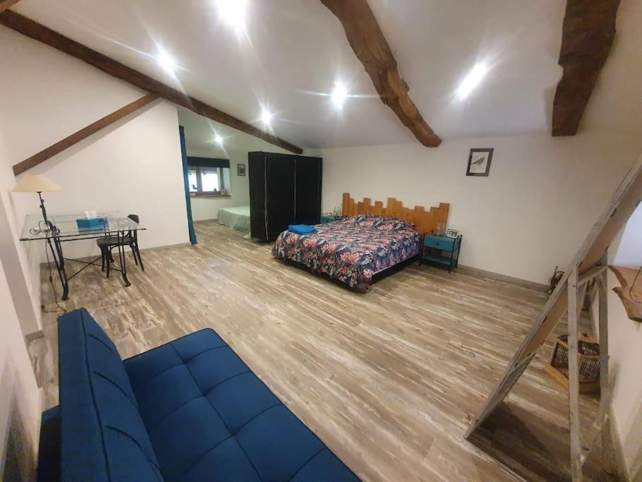 a bedroom with a bed and a table in a room at studio 2 spacieux 1à4 pers in Marboz