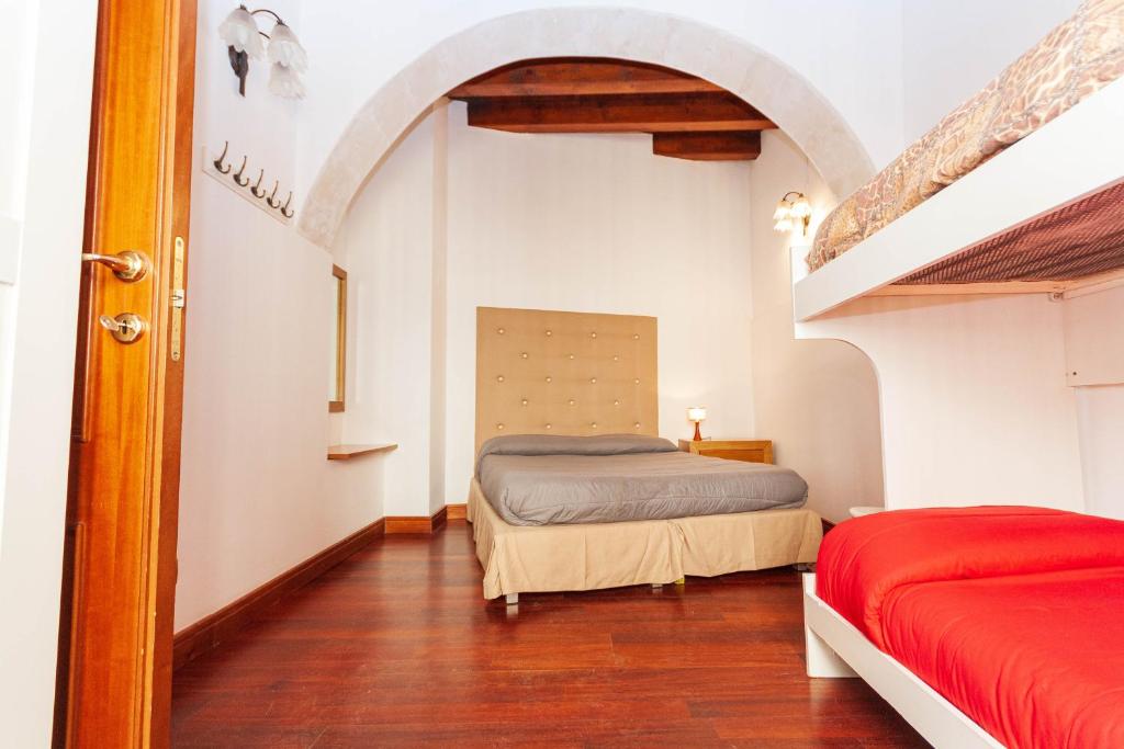 a bedroom with two beds and a staircase at Talete Palace in Siracusa