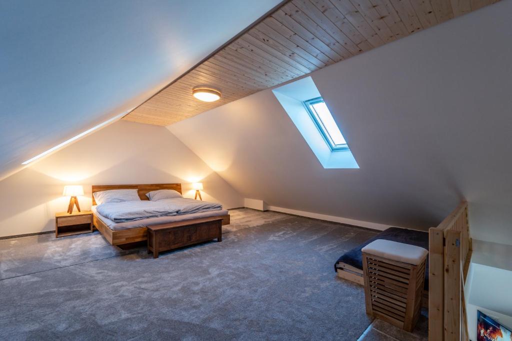 - une chambre mansardée avec un lit et une lucarne dans l'établissement Mezonetový apartmán Pernink, à Pernink