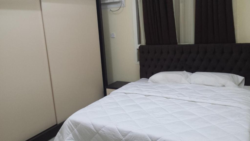 سرير أو أسرّة في غرفة في غولدن سيزنز للشقق الفندقية