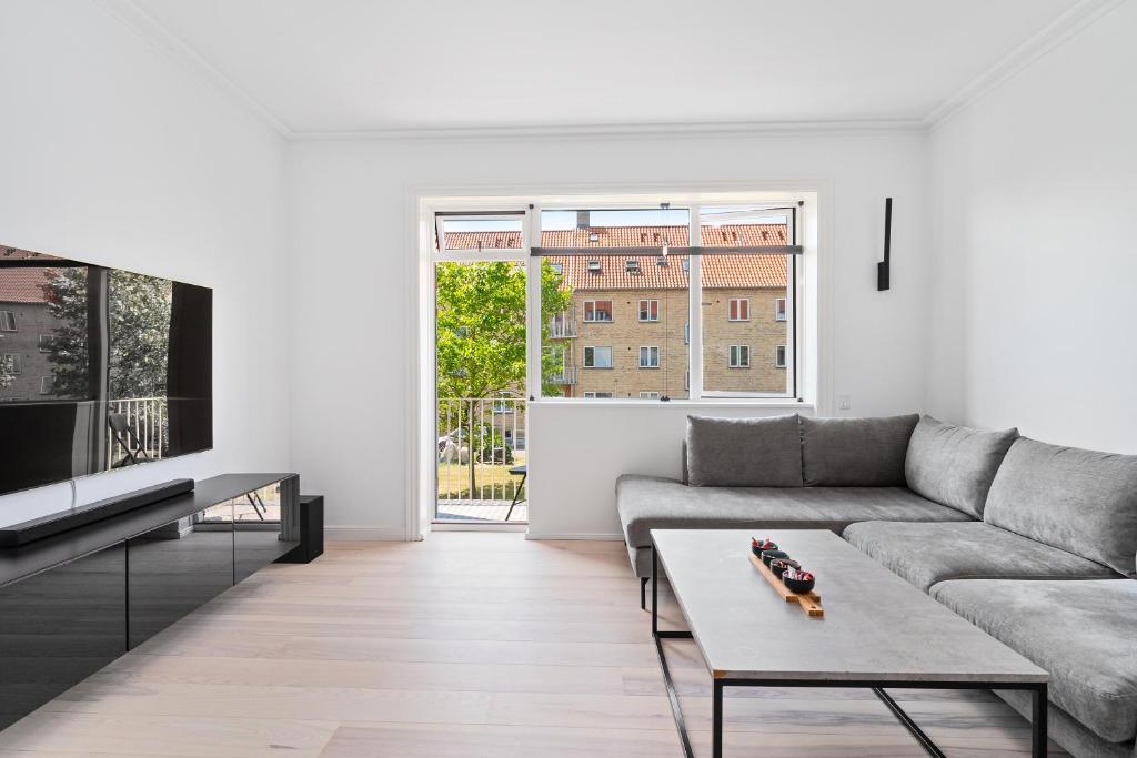 a living room with a couch and a tv at Modern Central Located Apartment in Copenhagen